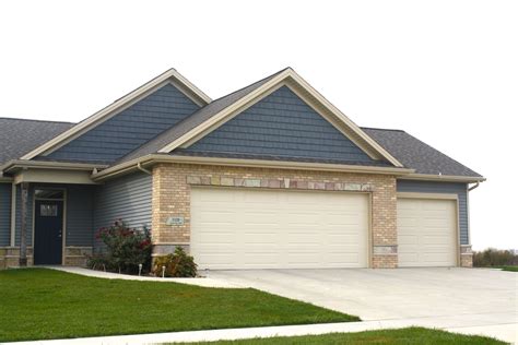 tan brick house with blue trim and metal roof|blue brick exterior ideas.